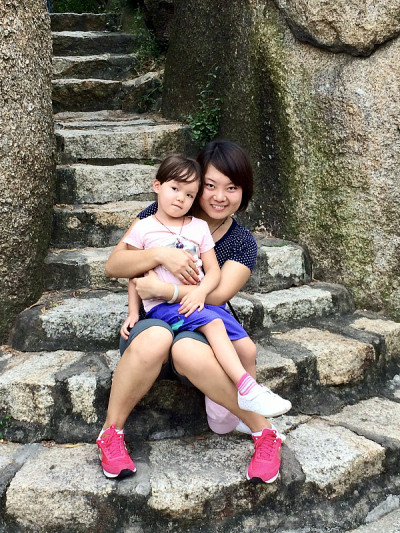 母亲和女儿在独特的岩石裂缝台阶上。