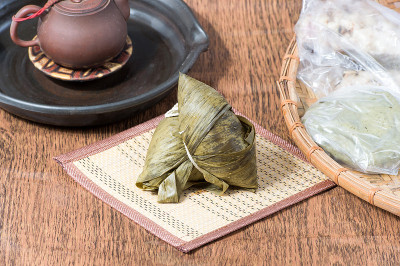 木桌上放着粽子和茶杯