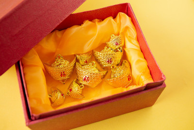 春节装饰用吉祥金条孤立在黄色上。春节假期。文字的翻译出现在图像中:好运好运