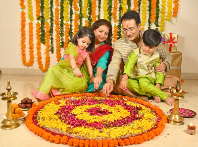 一家人在家里以传统的服装装饰rangoli