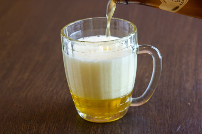在酒吧把啤酒从瓶子倒进马克杯