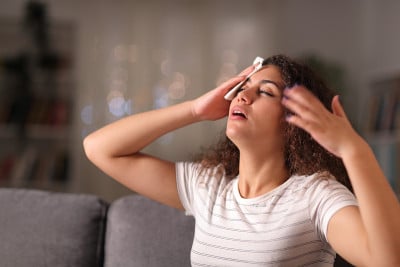 紧张的女人在一个温暖的晚上在家里干汗