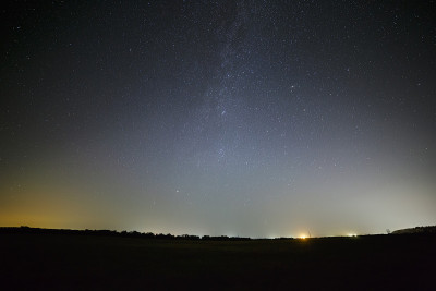 在仙女座星系夜空上方出现了一个明亮的光污染点。观察城外的星星。