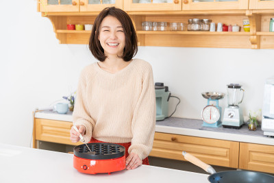 年轻的亚洲女人在厨房里烤章鱼烧，章鱼球，