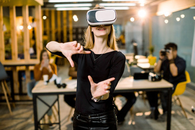 女人在虚拟现实头盔触摸物体在虚拟现实。女孩与3d可视化互动。数字模拟器概念的现代IT产品测试。团队的