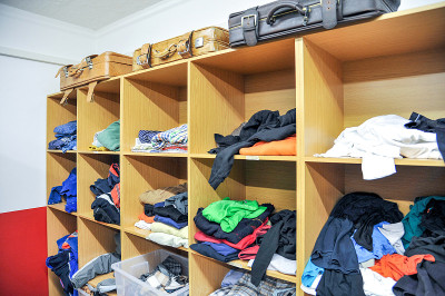 二手店里的衣架上摆满了各式各样的旧衣服、纺织品和配饰