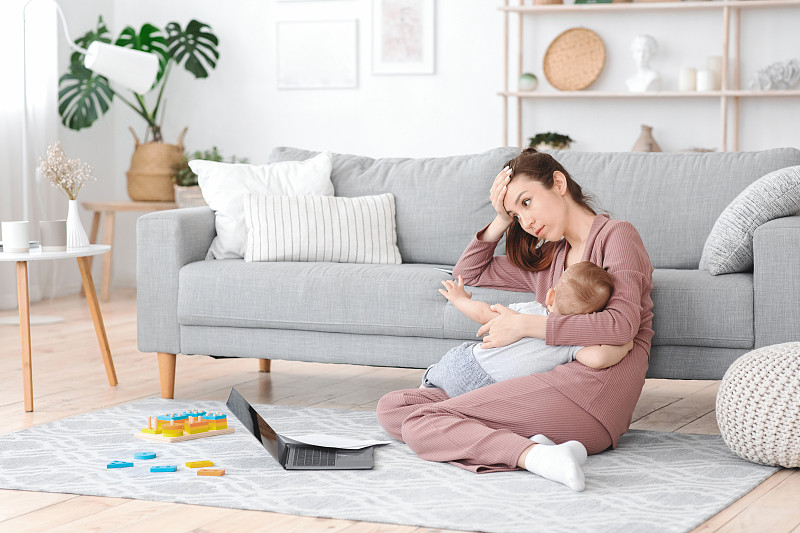 Motherhood Exhaustion. Tired mom breastfeeding bab