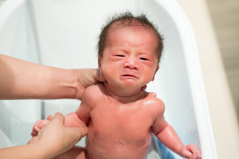 亚洲新生男婴在浴缸洗澡，9天的生命，孩子的概念