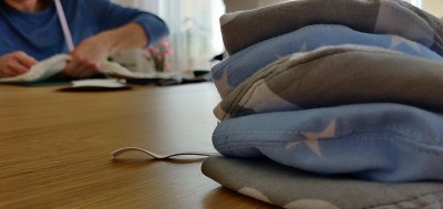 Self-sewing防护面具。桌上放自制的防护口罩和几块布