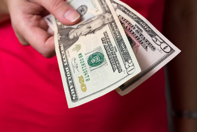 女人给钱。手里拿着现金。