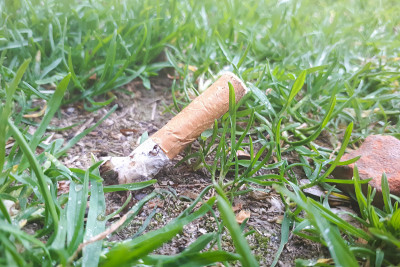 一根香烟在草地上像垃圾一样