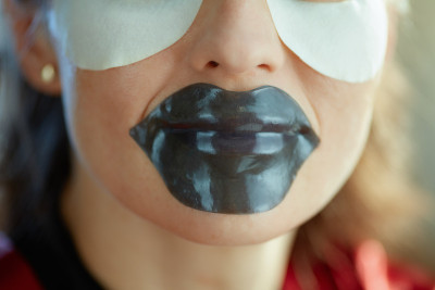特写的女人与水凝胶嘴唇面膜和眼罩