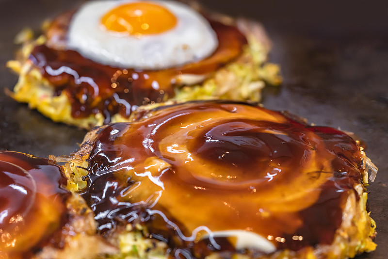 Japanese okonomiyaki omelet brushed over with sauc