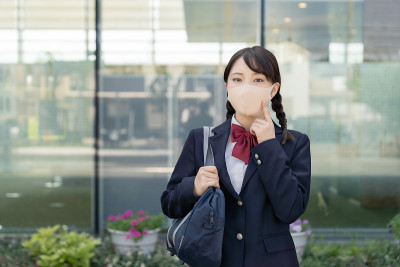 亚洲女高中生戴着面具。预防感染。