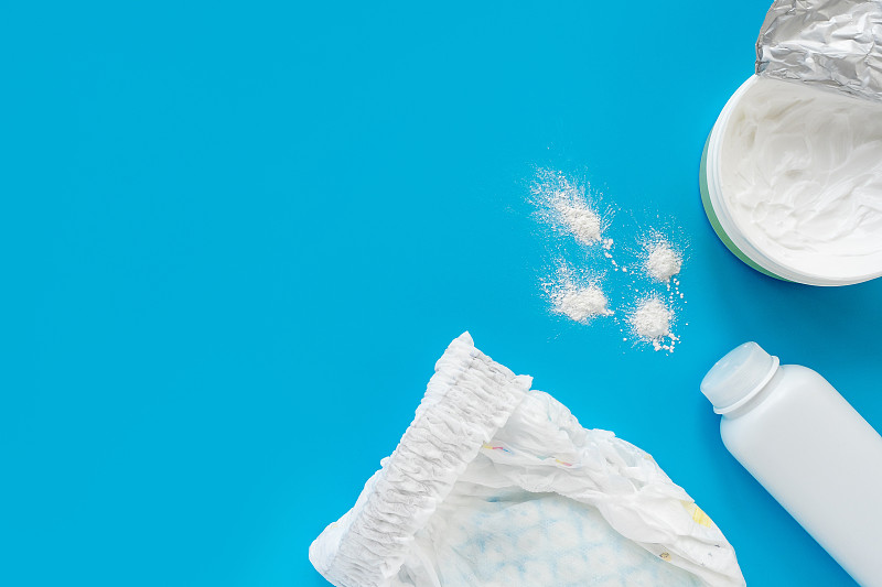 White powder, diaper, cream, napkin on a blue back