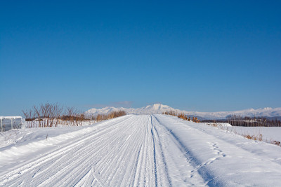在一个阳光明媚的冬日，白雪覆盖的道路和高山