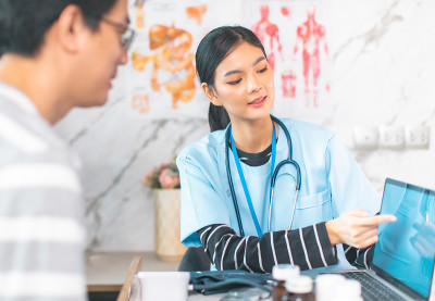 医生的手持视图测量他的病人的压力。一名医护人员正在为一名年轻女子检查血压。