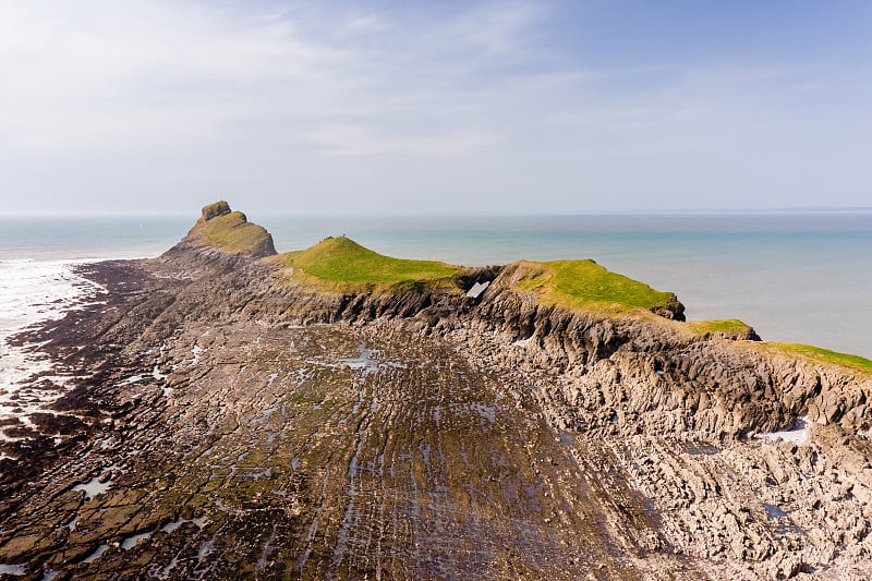 退潮时壮观的岩石海岸鸟瞰图(威尔士Worm's Head)