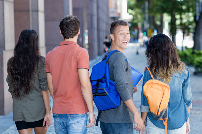英俊的白人男学生与一群年轻的成年人在城市户外