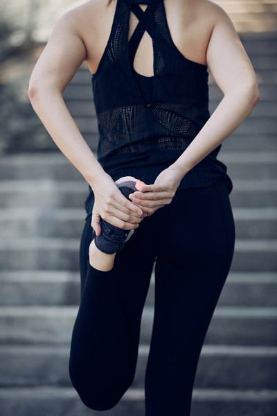 Closeup of attractive fit sportswoman stretching h