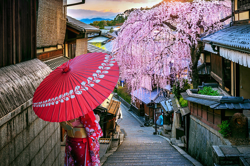 春天，日本京都，一名身穿日本传统和服的女子在历史街区东山行走。