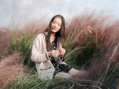 美丽的中国女孩的肖像，抱着粉红色的头发在头发多的领域。