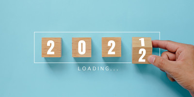 手工翻转木制立方体块的蓝色背景变化2021年至2022年。新年和节日的概念。