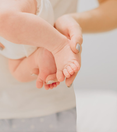 妈妈一手抱着小可爱的新生婴儿的脚脚趾