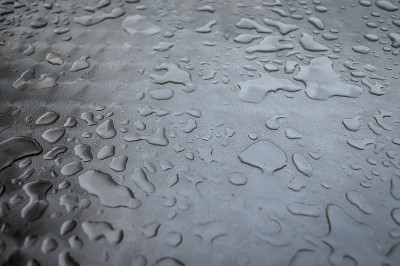 近距离观看雨水滴在金属表面