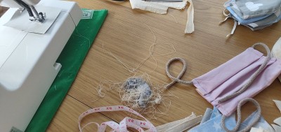 Self-sewing防护面具。桌上放自制的防护口罩和几块布
