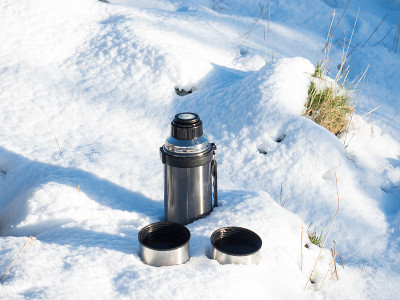 雪中装有两个杯子的茶壶