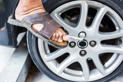 Man changing tire with wheel wrench