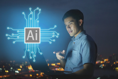 商人站在屋顶上，用笔记本电脑握住(AI)人工智能全息图，智慧城市和网络连接的概念