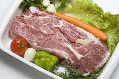 牛肩肉片配生蔬菜放在白背盘上