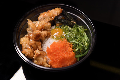 韩式炸鸡，配上鱼卵和海带，装在黑色的塑料盒里。