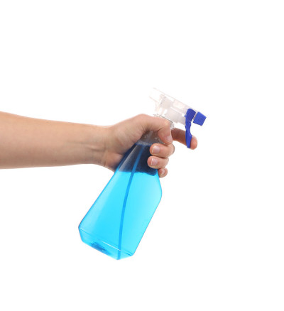 手里拿着蓝色塑料喷雾器。
