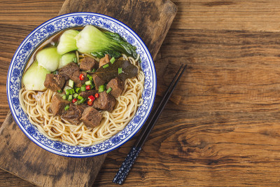 麻辣红汤牛肉面放在木桌上的碗里