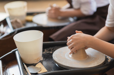 两个女陶瓷艺术家在围裙使用粘土材料在陶艺工作室工作。晚上自由远程学习。成人业余爱好冒险。冬季休闲教育