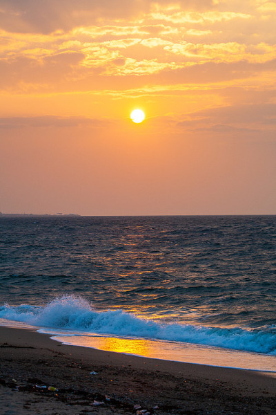 夕阳和蓝色的波光粼粼的海浪