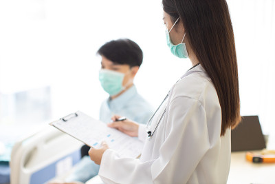 手持医生测量病人的压力。医疗工作者在检查血压或其他健康的年轻人期间。