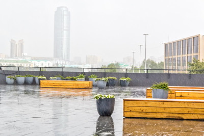 阳台上有花容器和雨中的木凳