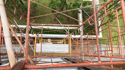 建筑行业的多层建筑与脚手架，在建筑脚手架和建筑工地建筑的灰泥墙上建造一个新家园。