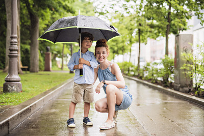 妈妈和孩子在一个下雨天带着伞在公园里