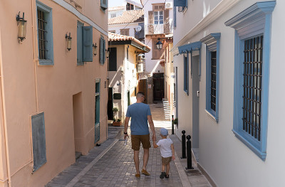 父亲和儿子走在希腊Nafplion狭窄的街道上。家庭周末和观光