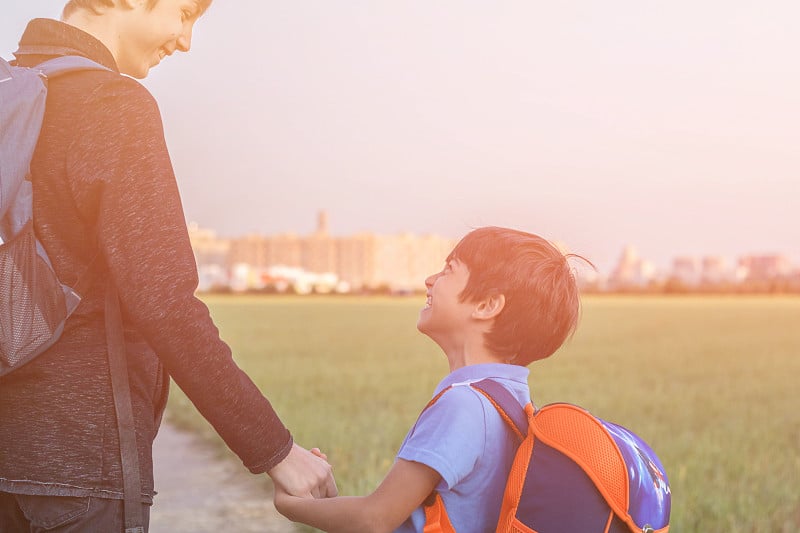 兄弟们去上学。十几岁的少年和弟弟手拉着手，兄弟们脸上挂着孩子们快乐的笑容。回到学校