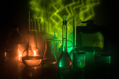 药学和化学主题。在研究实验室用溶液测试玻璃烧瓶。科学和医学背景。深色背景上的实验室试管