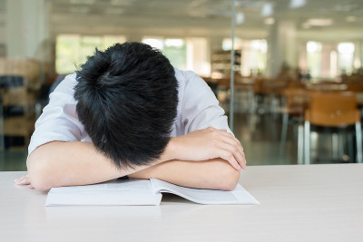亚洲男学生坐在大讲堂睡觉