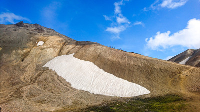 在冰岛的Landmannalaugar的斜坡上，沿着山脊沿着雪舌徒步旅行