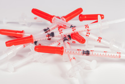 一堆带红色安全帽的空注射器