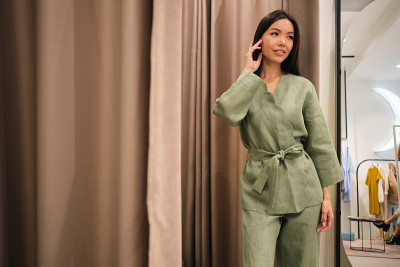 漂亮的亚洲女孩穿着时髦的西装梦幻地摆造型在现代服装店的更衣室